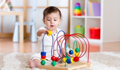 Baby,girl,playing,with,educational,toy,in,nursery