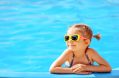 Smiling,cute,little,girl,in,sunglasses,in,pool,in,sunny