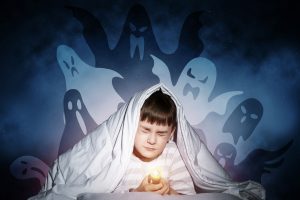 Young,boy,hiding,under,blanket,from,imaginary,ghosts.,scared,kid